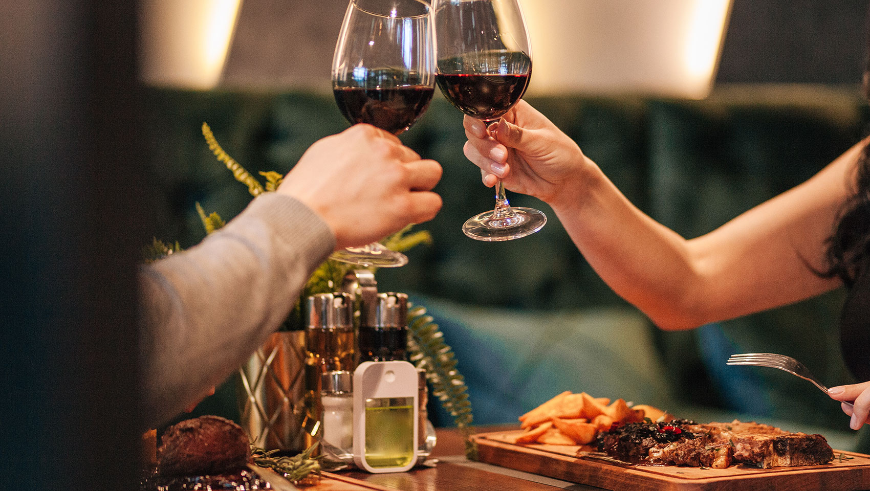 couple having dinner, raises glasses of wine