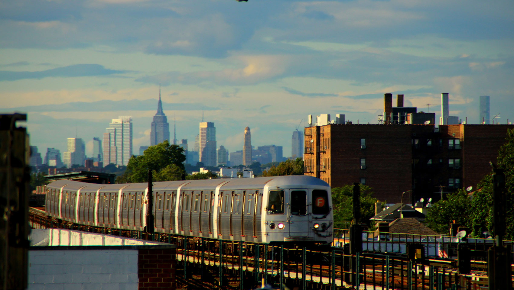 train in tracks with NYC skyline in the background