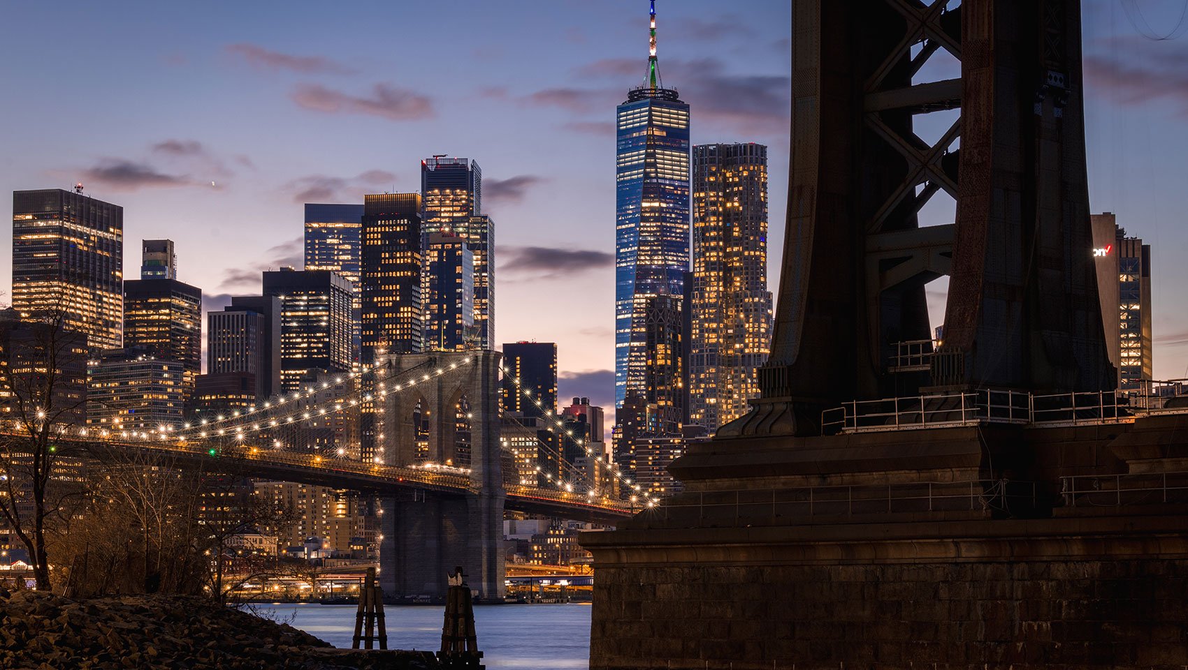 nyc skyline under bridge at night